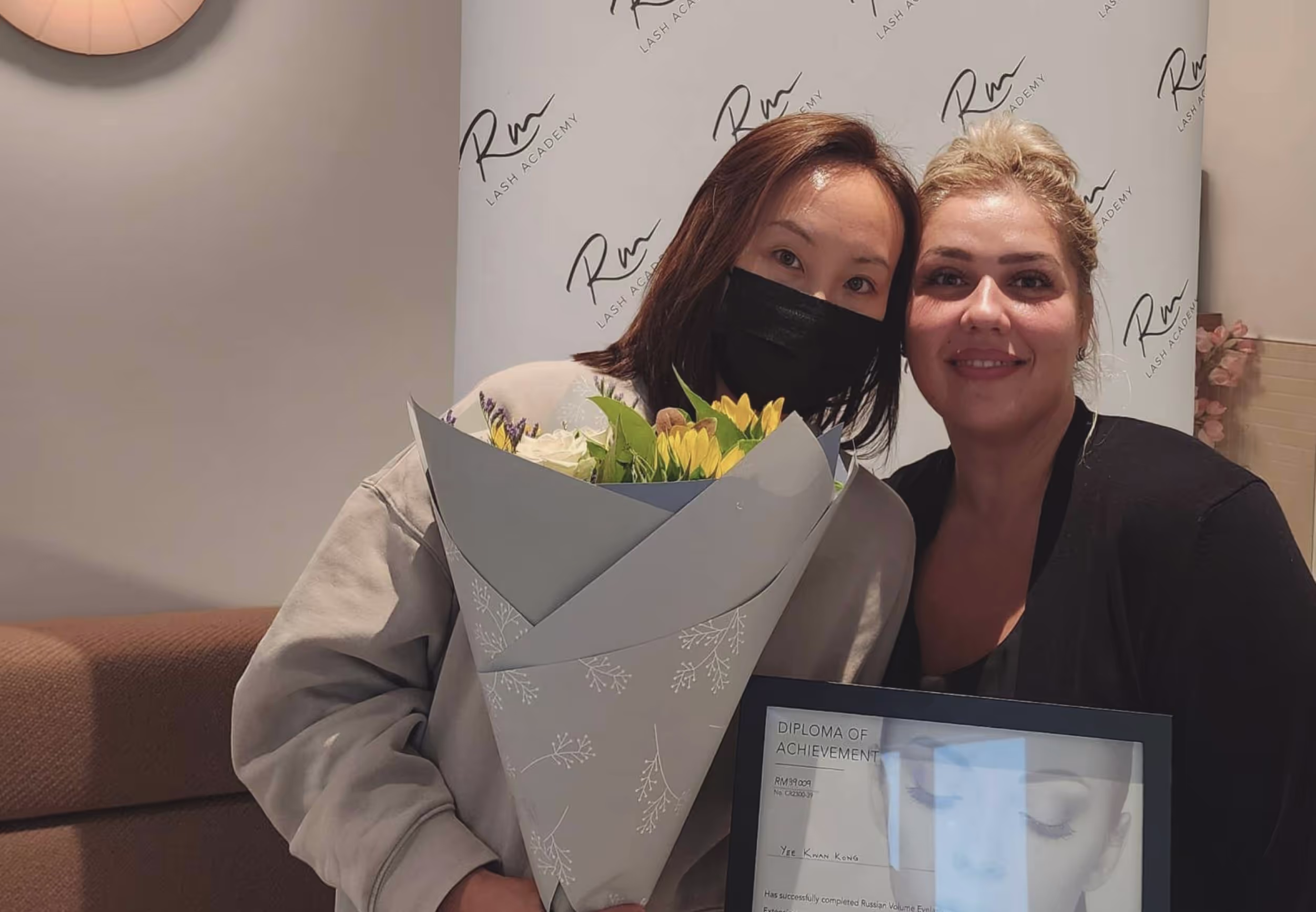 Lash student and trainer holding a certificate.