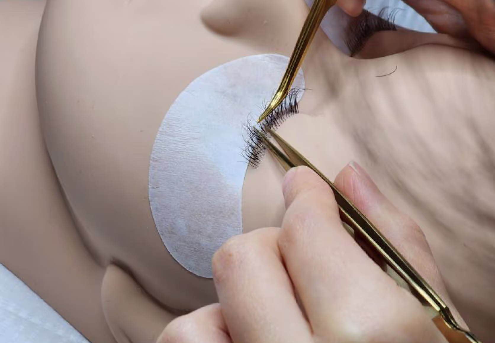 Applying lash extensions on a mannequin.