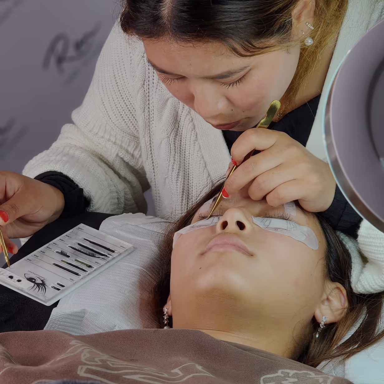Lash student practising eyelash extension application on a model during hands-on training.