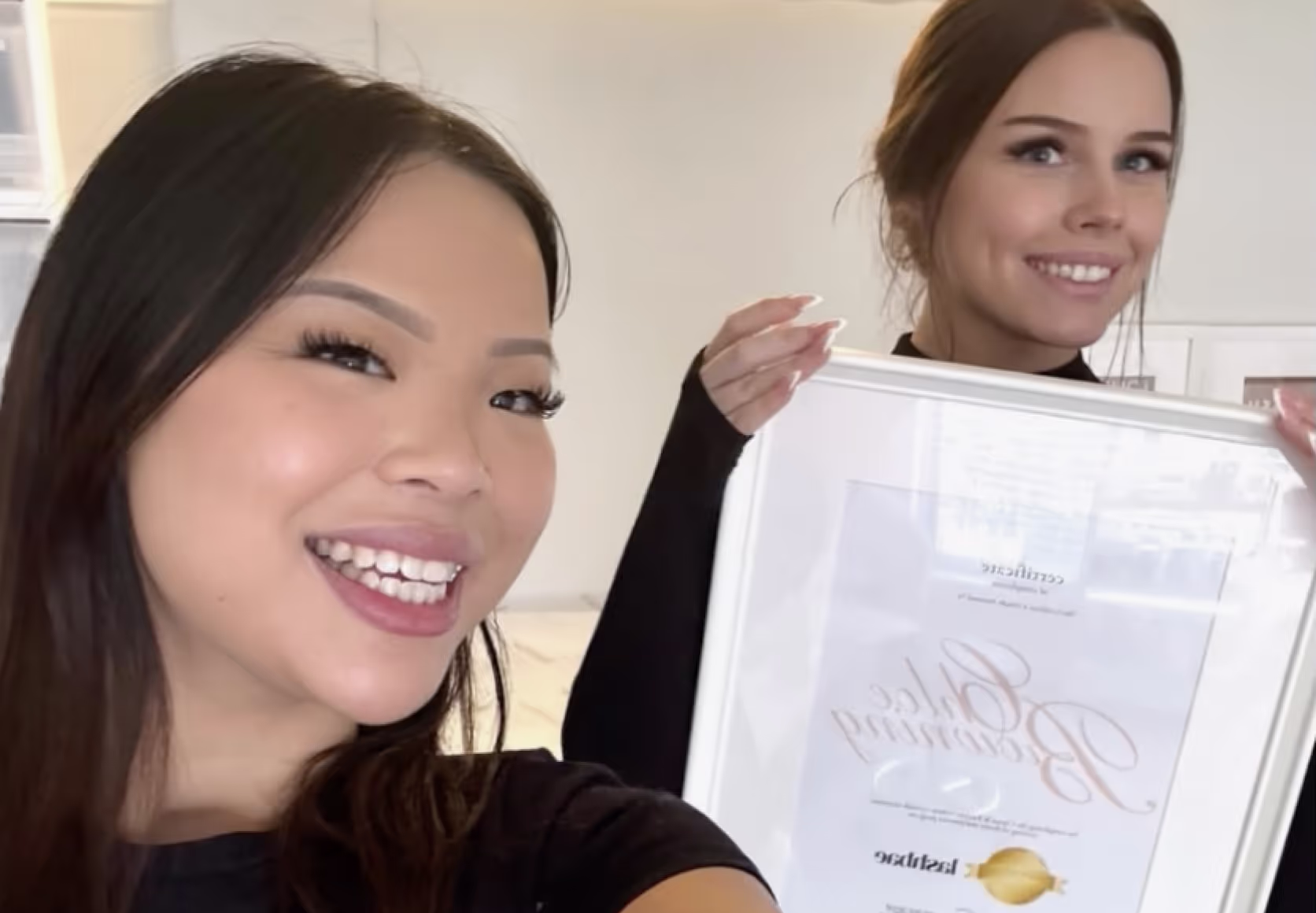 Accredited lash educator with students holding lash extension training certificates after course completion.
