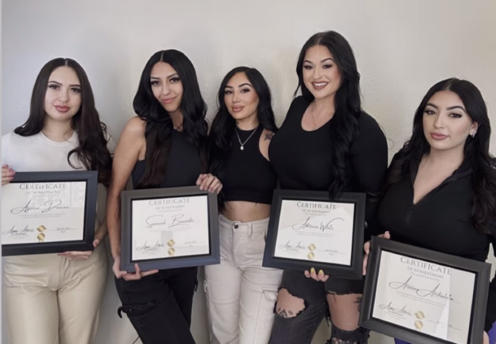 Group of new certified lash artists with their trainer, celebrating successful lash training completion.