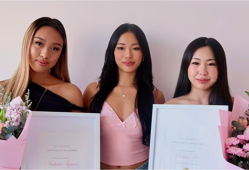 GLO Artistry lash training graduates proudly holding certificates after completing accredited lash educator course.