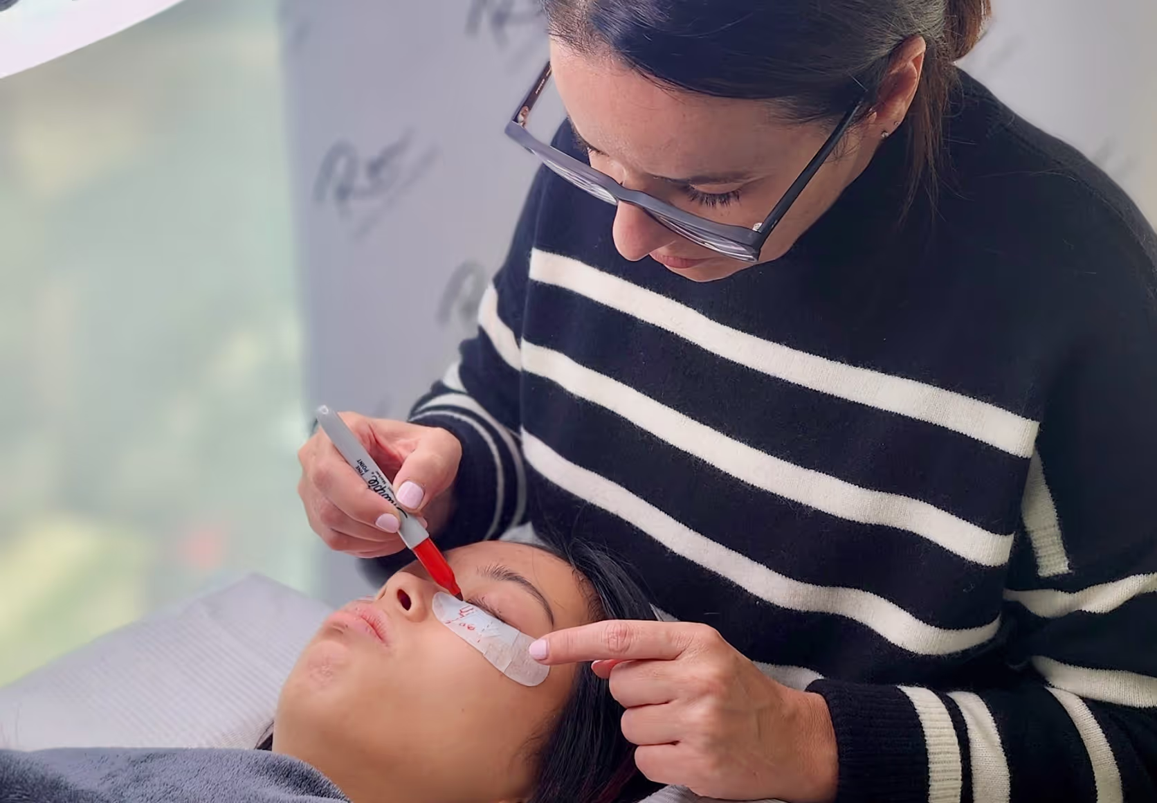 Applying lash extensions on a mannequin.