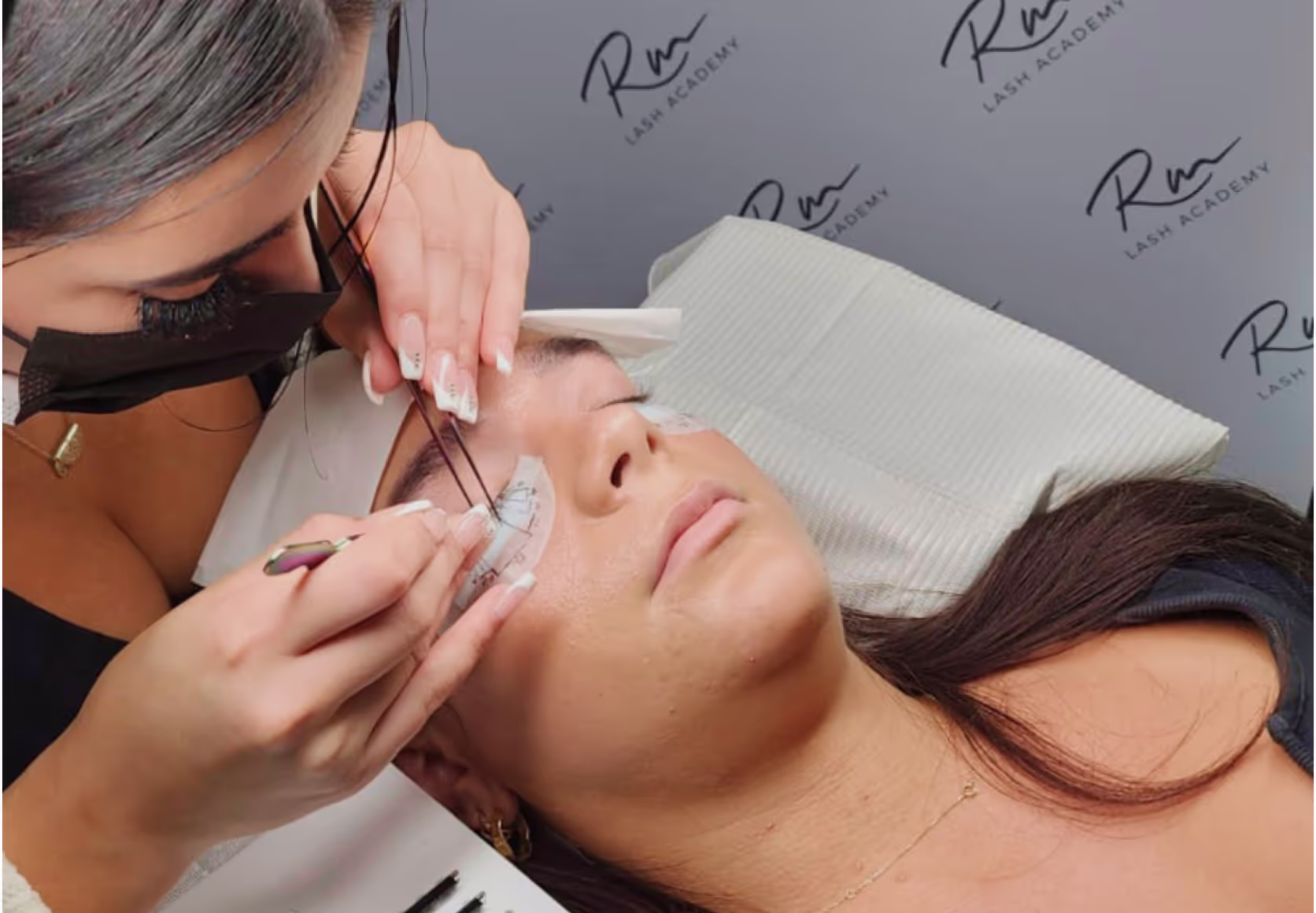 Student in classroom applying lashes during training.