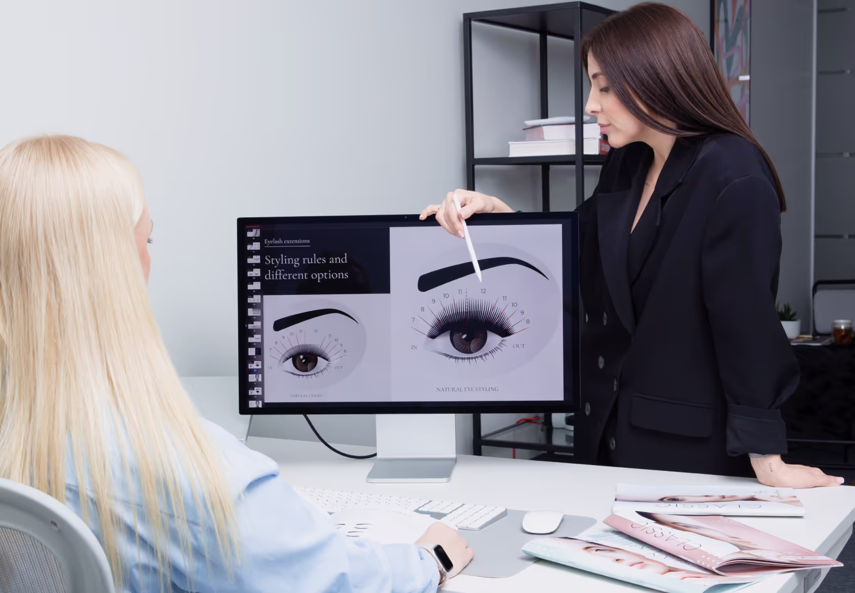 Lash educator explaining lash map on screen to student.