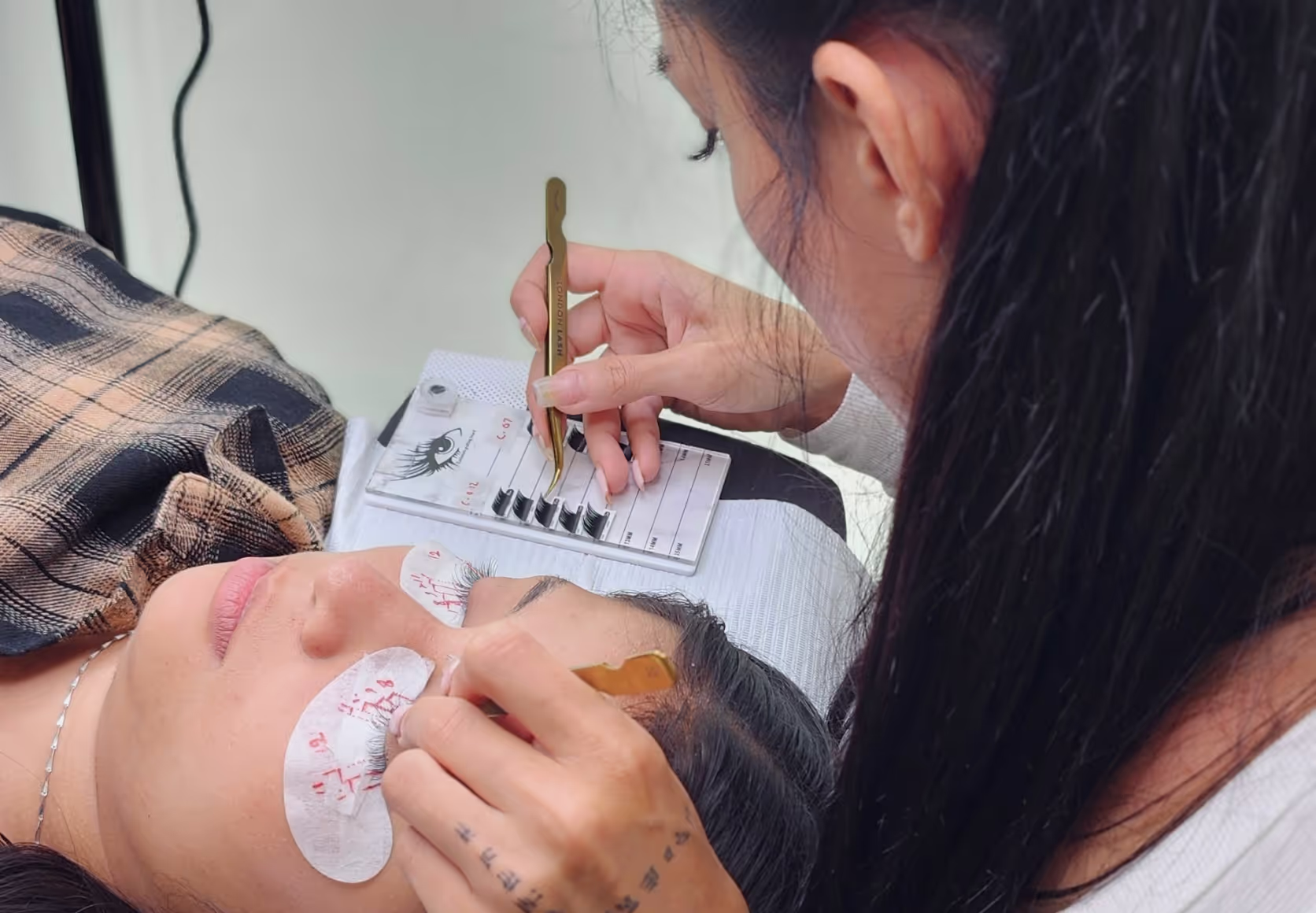 Student in classroom applying lashes during training.