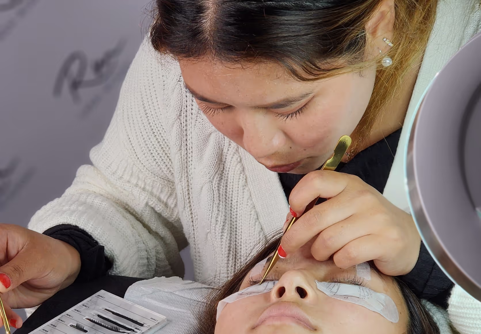 Student in classroom applying lashes during training.