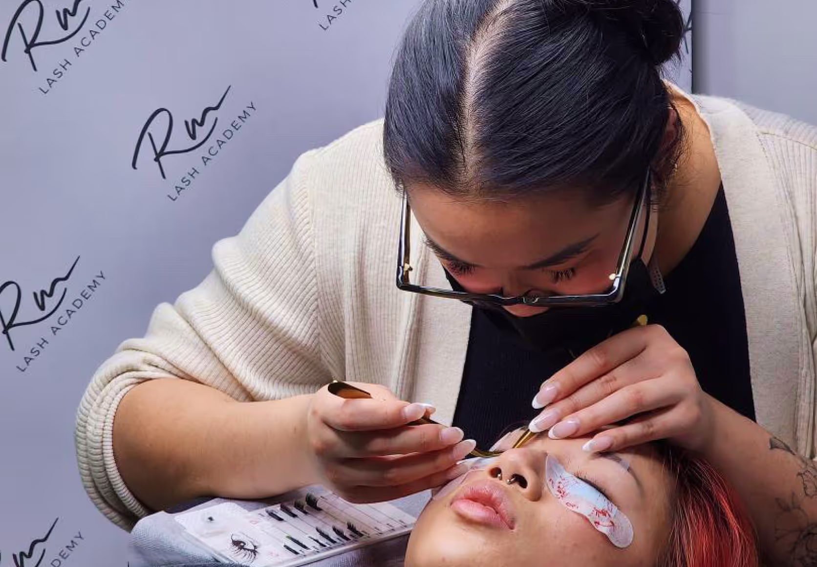 Student in classroom applying lashes during training.